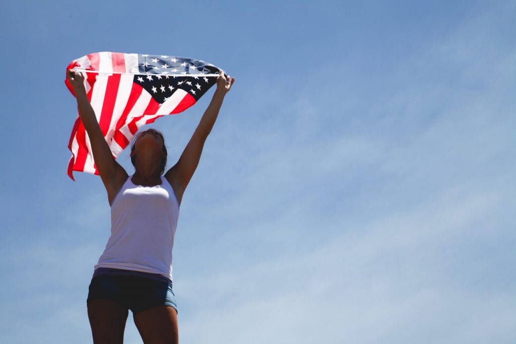 vrouw houdt Amerikaanse vlag vast tijdens road trip